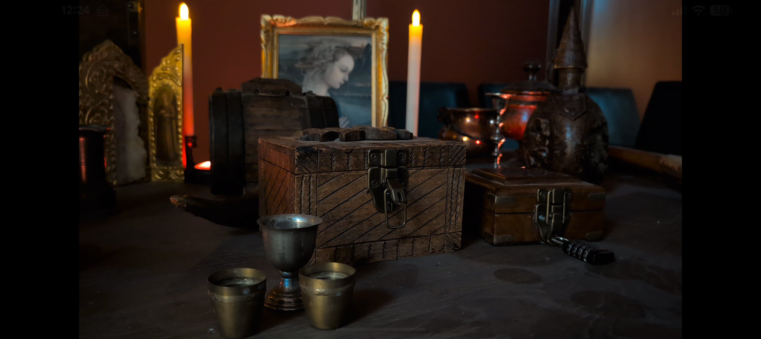 Décor de L’Héritage des Séquanes avec coffre en bois, bougies et ambiance médiévale